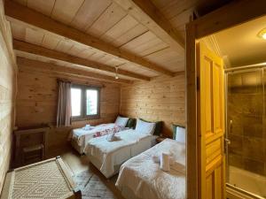 a bedroom with two beds in a log cabin at POKUT orion in Çamlıhemşin
