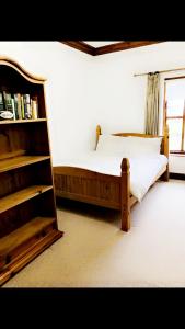 阿馬的住宿－Ridge Wood House，一间卧室设有一张床和一个书架