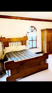 a wooden bed in a room with a window at Ridge Wood House in Armagh