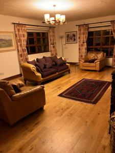 a living room with two couches and a rug at Ridge Wood House in Armagh