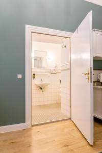 Baño con aseo y lavabo a través de una puerta en Apartments-Maison Am Olivaer Platz, en Berlín