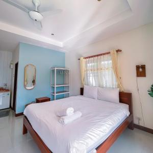 1 dormitorio con 1 cama blanca grande y ventana en Ther เธอ Villa พูลวิลล่าปราณบุรี, en Pran Buri