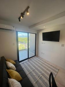 sala de estar con sofá y TV de pantalla plana en Departamento único para 3 personas en Salta Capital en Salta