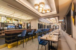 un restaurant avec un long bar et des chaises bleues dans l'établissement Eurostars Lisboa Baixa, à Lisbonne
