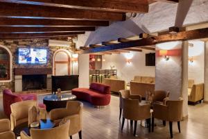 a lobby with chairs and tables and a tv at Hotel Kabila in M'diq