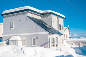 um edifício com neve em frente em Home Yasuda em Otaru