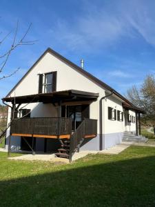 Dieses weiße Haus verfügt über eine Veranda und einen Balkon. in der Unterkunft Maribor Luxury Country House Volicina 5* 