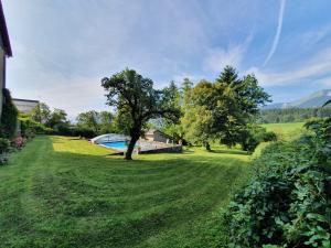 un patio con un árbol y una piscina en La belle des praz en Mieussy