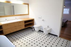 ein Badezimmer mit einem Waschbecken, einem WC und einem Spiegel in der Unterkunft Maribor Luxury Country House Volicina 5* 