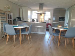 a kitchen and dining room with two tables and chairs at Bij de oude dijk in Wilp