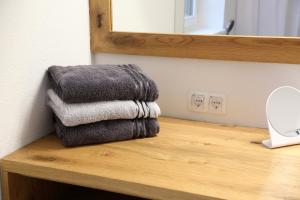 einen Haufen Handtücher auf einer Holztheke im Bad in der Unterkunft Maribor Luxury Country House Volicina 5* 