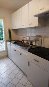 Una cocina con gabinetes blancos y una encimera negra. en Zoo Zen 6 pers, au coeur de St Aignan, en Saint-Aignan