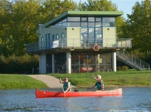 Dos personas en un kayak rojo en el agua frente a una casa. en Zoo Zen 6 pers, au coeur de St Aignan, en Saint-Aignan 3 fotos más