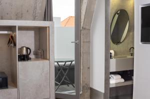 a bathroom with a mirror and a sink at Hotel Cajú in Funchal