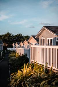 a row of pink houses with a white fence at Croyde Bay Hotel or Self Catering in Croyde