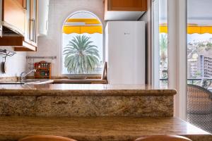 a kitchen with a large window with a palm tree at Apartamento en Aquamarina in Mogán