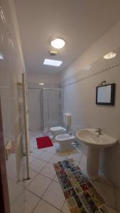 ein Badezimmer mit 2 WCs und einem Waschbecken sowie einem TV in der Unterkunft Villesse Appartamenti 