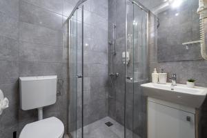 y baño con ducha, aseo y lavamanos. en Synagogue Apartments, en Budapest