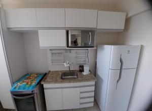 una pequeña cocina con fregadero y nevera. en Apartamento com 2 quartos de FRENTE PARA O MAR en Maceió