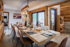 uma sala de jantar com uma grande mesa de madeira e cadeiras em Chalet Vivaldaim - OVO Network em La Rivière-Enverse