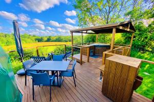 a deck with tables and chairs and a hot tub at Finest Retreats - Scotney Luxury Dome 