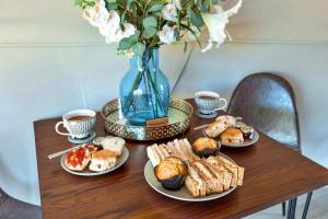a table with plates of food and a vase of flowers at Finest Retreats - Scotney Luxury Dome in Hoath