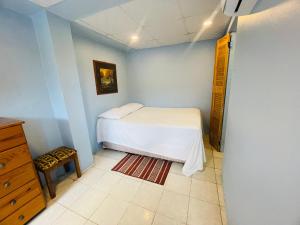 a small bedroom with a bed and a dresser at Las Cuevas Boutique Hotel in Las Cuevas