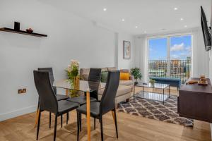 ein Wohnzimmer mit einem Tisch, Stühlen und einem Sofa in der Unterkunft Queen Elizabeth Olympic Park Apartment in London