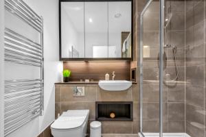 ein Bad mit einem WC, einem Waschbecken und einer Dusche in der Unterkunft Queen Elizabeth Olympic Park Apartment in London