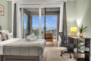 - une chambre avec un lit, un bureau et un balcon dans l'établissement Queen Elizabeth Olympic Park Apartment, à Londres