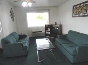 a living room with two blue couches and a tv at Sallisaw Inn in Sallisaw