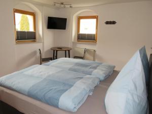 a bed in a room with a table and two windows at Doppelzimmer Dresden - Wilschdorf Monteurunterkunft in Dresden