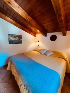 a large bed in a room with a wooden ceiling at JP House Amalfi in Amalfi