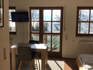 comedor con mesa y ventanas en Ferienwohnung Seebruck am Chiemsee en Seebruck