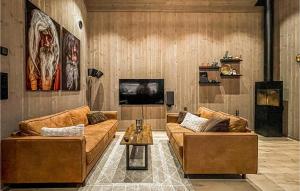 uma sala de estar com dois sofás castanhos e uma televisão em Amazing Home In seral With Kitchen em Åseral