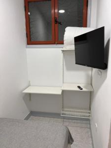 een kamer met een bed en een tv aan de muur bij CH Barco in Madrid