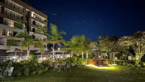 a hotel yard with tables and chairs at night at Hotel Lagoon in Rionegro