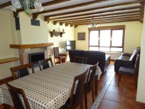 - une salle à manger avec une table, des chaises et un canapé dans l'établissement El soportal, à Barbadillo del Pez