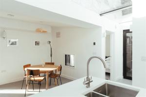 uma cozinha e sala de jantar com uma mesa e um lavatório em The Hopper Huts em Faversham