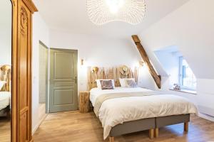 1 dormitorio con cama y lámpara de araña en Gite La Petite Ferme en Clermont-les-Fermes