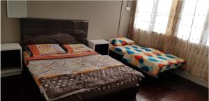 a bedroom with two beds and a window at J & I Homestay B 3 Person with shared bathroom in Sibu