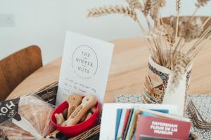 uma mesa com livros e um vaso com livros em The Hopper Huts em Faversham