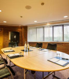a conference room with a large wooden table and chairs at Abbey Hotel Golf & Spa in Redditch +74 photos