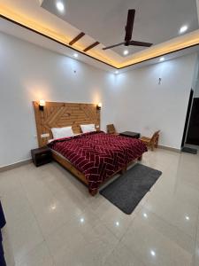 um quarto com uma cama grande e um edredão vermelho em HOTEL HIMALAYAN FOXHOLE em Chakrāta