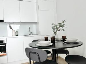 a kitchen with a table with bowls and chairs at Tammer Huoneistot - City Suite 4 - Perfect Location & Great Amenities in Tampere