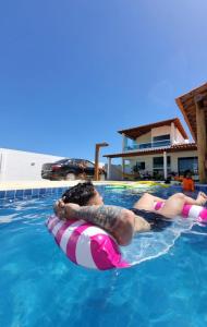 2 personnes flottent dans une piscine dans l'établissement Casa PatachAmar, à Porto de Pedras
