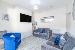a living room with two couches and a flat screen tv at Serviced Accommodation 5 Bedroom Holiday House in Liverpool
