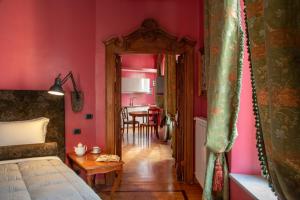 1 dormitorio con paredes rosas y mesa con sillas en Room 94 Luxury, en Roma