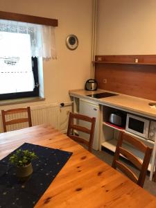 a kitchen with a wooden table and a counter top at Apartmán Šírovi in Benecko