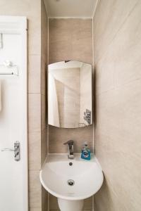 a bathroom with a white sink and a mirror at [COVENT GARDEN] Apartment in Central London in London